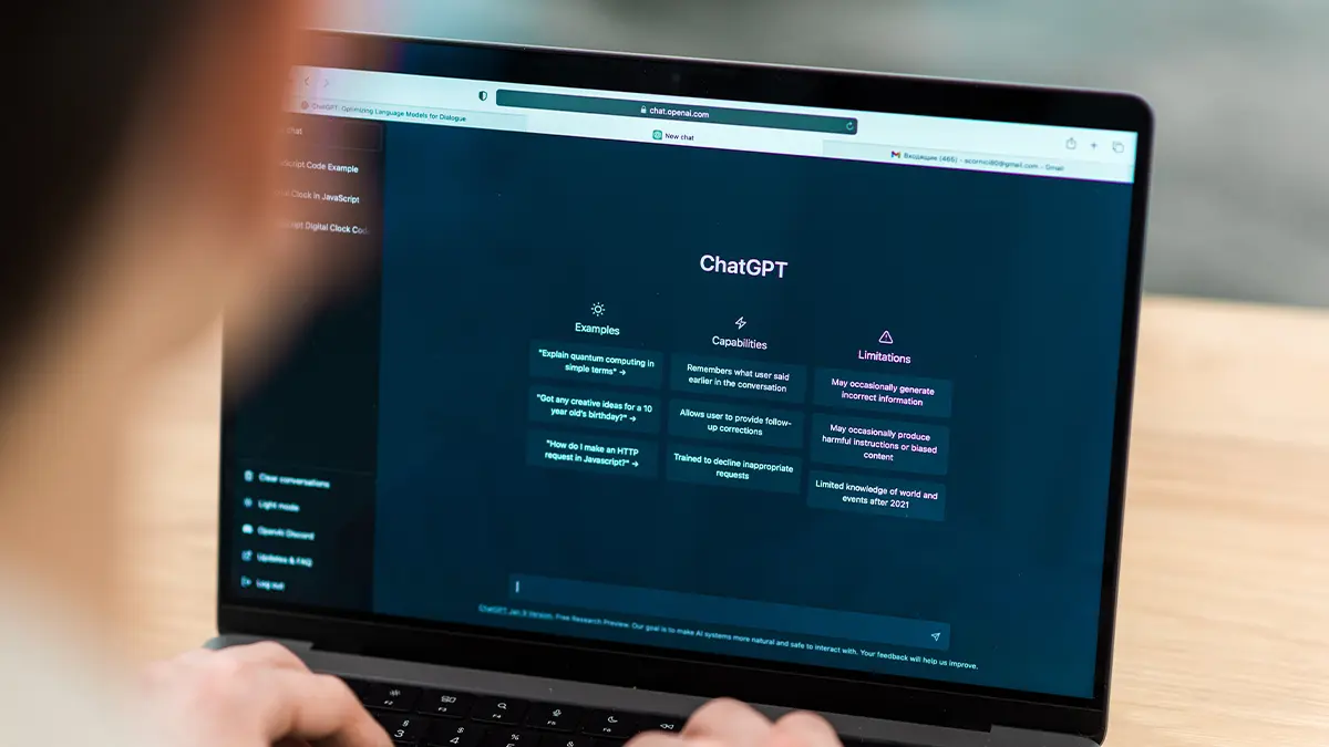 Laptop screen showing ChatGPT, person typing a prompt.